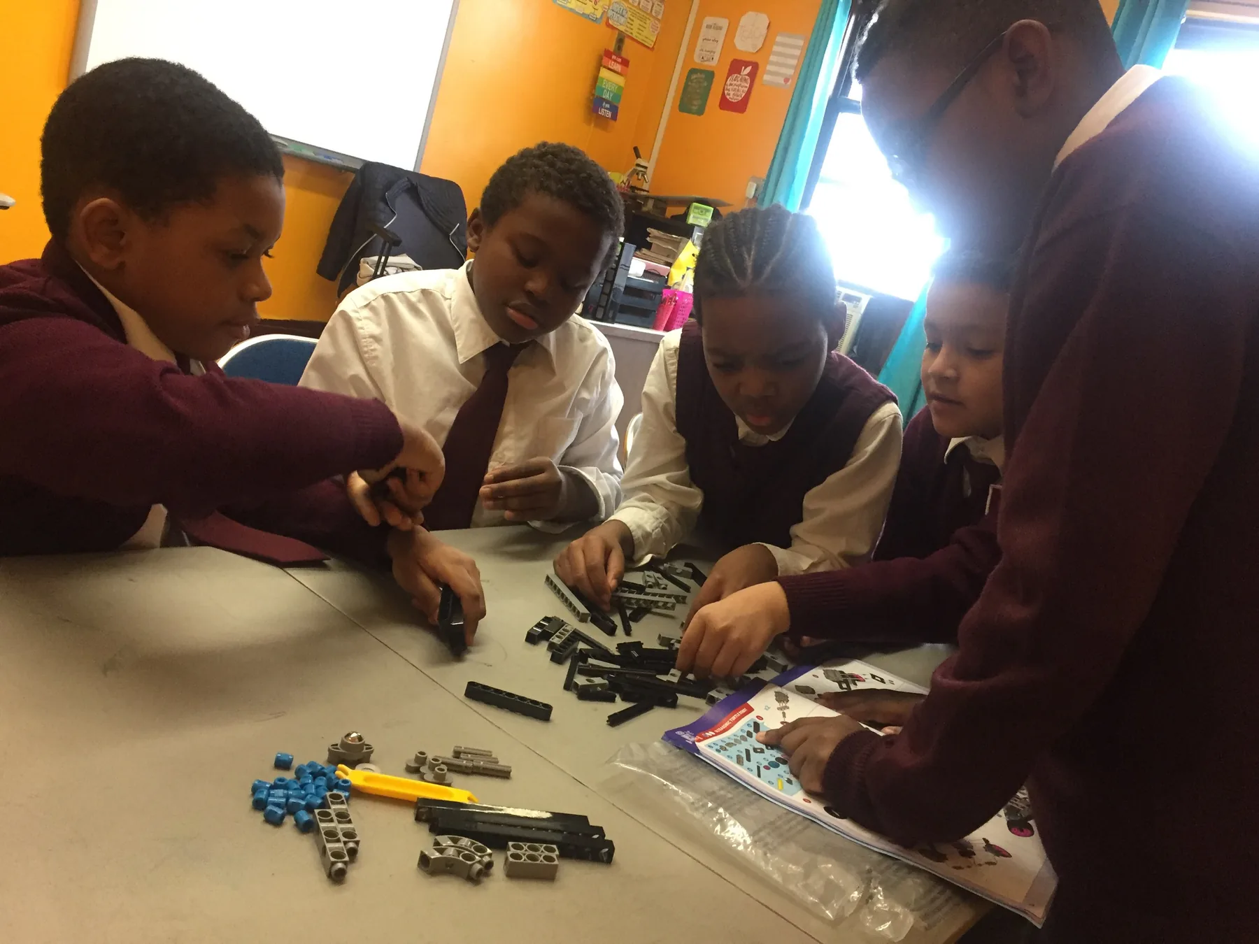Students building a kit together at a classroom table